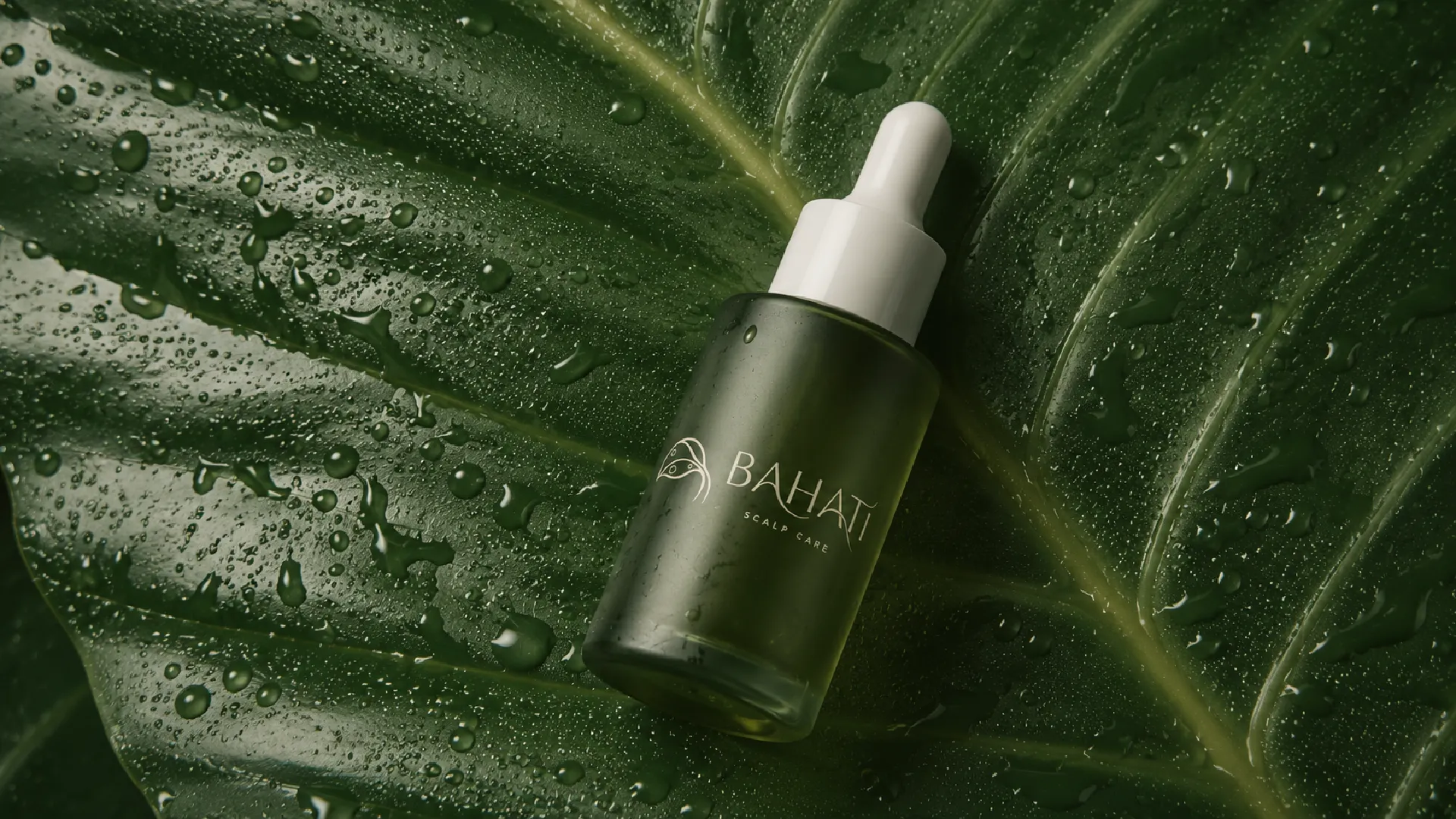 Bahati scalp oil dropper on a wet leaf